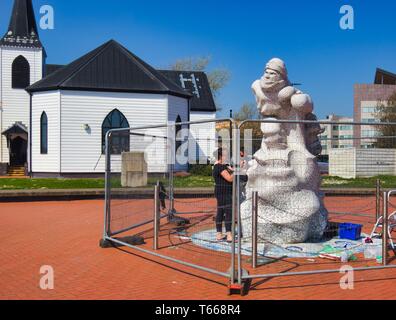 Scott Antarktis Memorial wird im Jahr 2018 mit der Norwegischen Kirche im Hintergrund, Cardiff Bay, Cardiff, Wales, Vereinigtes Königreich repariert Stockfoto