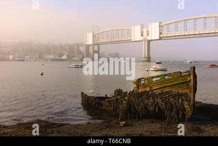 Royal Albert Bridge über den Fluss Tamar und Faule, verlassenen Boot am Flussufer in der Morgendämmerung in Plymouth, Devon, UK. Stockfoto