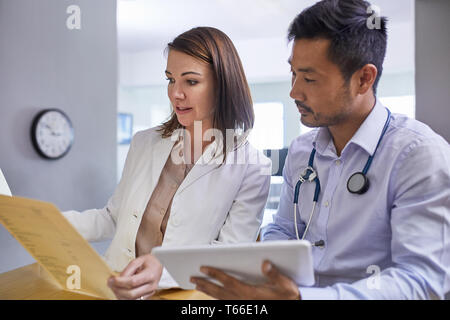 Ärzte diskutieren medizinische Aufzeichnung in der Klinik Stockfoto