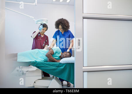 Weibliche Chirurg und Anästhesist Vorbereitung männliche Patienten für die Chirurgie Stockfoto