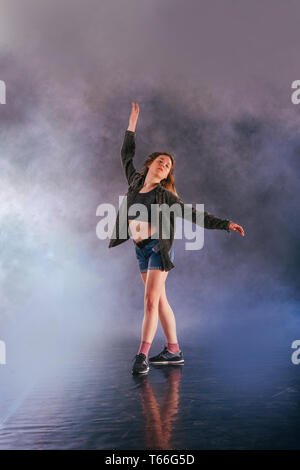 Tänzerin zeigt ihre Eleganz, indem sie ihr Bein hoch über den Kopf. Stockfoto