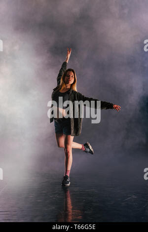 Tänzerin zeigt ihre Eleganz, indem sie ihr Bein hoch über den Kopf. Stockfoto