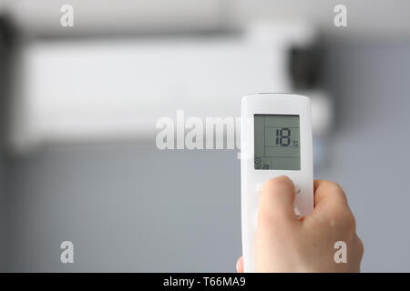 Männliche Hand halten Fernbedienung Klimaanlage Stockfoto