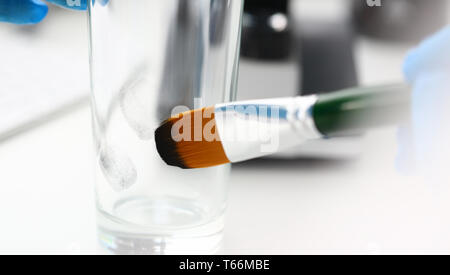 Männliche Hand in blu Schutzhandschuhe halten Sie die Bürste Stockfoto