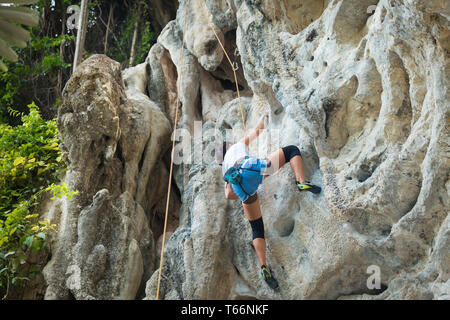 Junge Frau Klettern auf karst Kalkstein weißen Berg in Thailand. Stockfoto