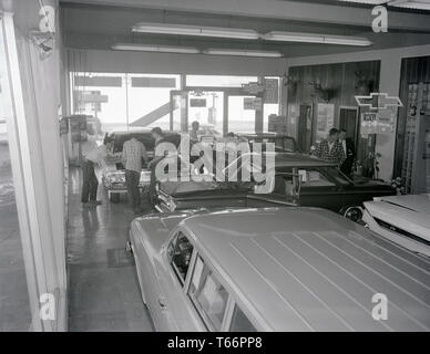 Antike 1961 Foto, innen ein Chevrolet Autohaus. Das Auto in der Mitte ist ein 1961 Chevy Corvair. Der Name "Impala" auf das weiße Auto auf ganz rechts sichtbar ist. Quelle: ORIGINAL NEGATIV Stockfoto