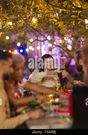 Freunde toasten Weingläser, genießen das Abendessen Garden Party Stockfoto