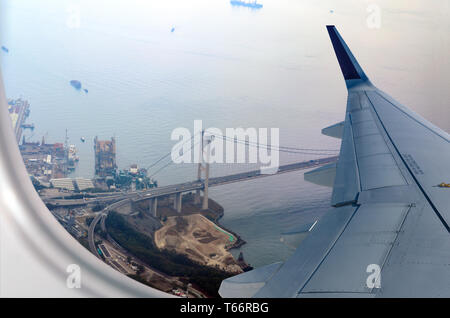 Flugzeug fliegt über Hongkong. Fensterplatz im Flugzeug mit Blick auf Kap Shui Mun Brücke, zwischen Tsing Yi und Ma Wan-Inseln. Stockfoto