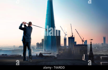 Geschäftsmann Schwingen Golf Club auf Stadt Hochhaus auf dem Dach Stockfoto