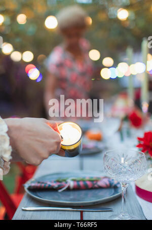 Frau Beleuchtung Kerzen für Abendessen Garden Party Stockfoto