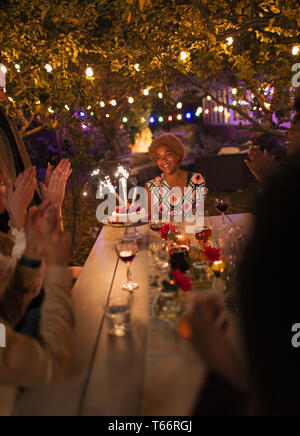 Gerne Freunde feiern Geburtstag mit Wunderkerzen Kuchen im Garden Party Tabelle Stockfoto