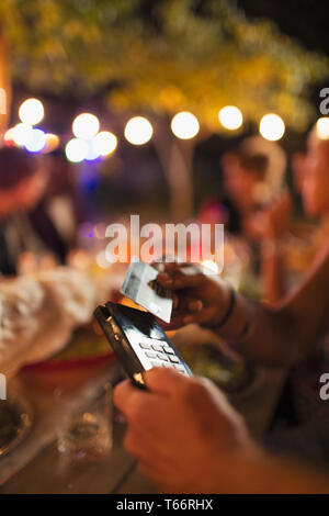 Frau Zahlung mit Smart Card im Patio Restaurant Stockfoto