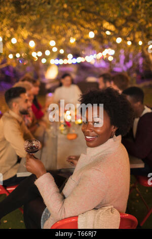 Portrait glückliche Frau, Wein trinken, genießen das Abendessen Garden Party Stockfoto