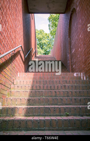 einen Tunnel wie Treppe mit roten Ziegeln und Handlauf Stockfoto