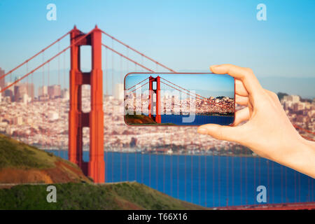 Touristische Hand halten Telefon und Bild Foto von Golden Bridge, San Francisco Panorama nehmen Stockfoto