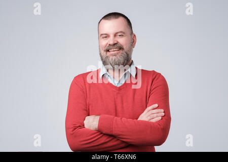 Charmante stattlicher Mann, die Arme verschränkt und laufhing, zuversichtlich. Stockfoto
