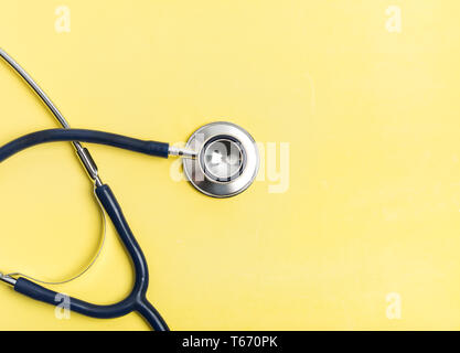 Stethoskop medizinische Geräte auf gelbem Hintergrund. Kopieren Sie Platz für Ihren Text. Medizin und Gesundheit Konzept. Stockfoto
