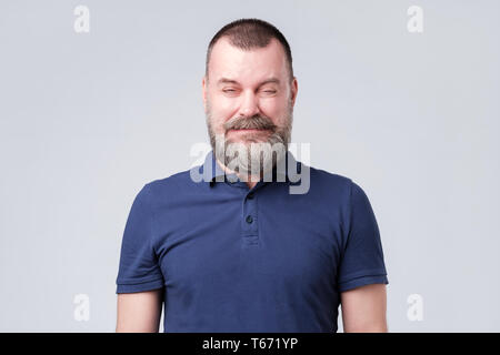 Reifer Mann im blauen Hemd zerknittert aufgrund der sauren Geschmack. Stockfoto