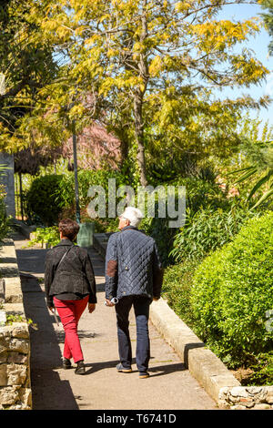 CANNES, Frankreich - April 2019: Mann und Frau zu Fuß durch die Gärten auf dem Weg bis zur katholischen Kirche Notre Dame d'Esperance in Cannes auf dem Französischen Stockfoto