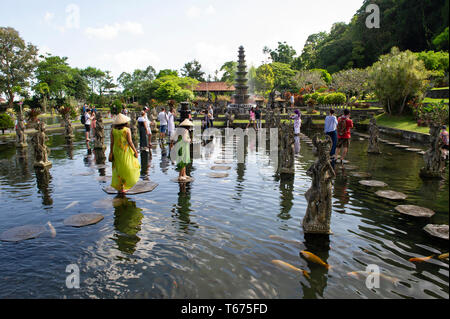 Touristen auf dem Stepping Stones bei Taman Tirtagangga (Die Königliche Wasser Palast und Gärten) in Bali, Indonesien Stockfoto