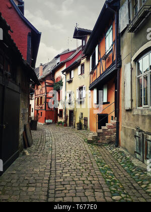 Die engen Gassen der alten Eguisheim Dorf mit Fachwerkhäusern mittelalterlichen Häusern entlang der berühmten Weinstraße im Elsass, Frankreich. Stockfoto