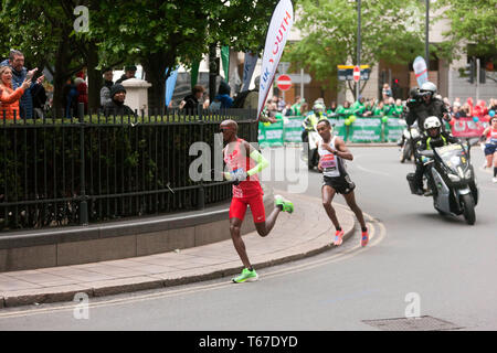 Sir Mo Farah (GBR), die durch die North Colonnade, Canary Wharf, dicht gefolgt von Leul Gebresilasie (ETH), während der 2019 London Marathon gefolgt. Bei den Herren Elite Rennen, Mo ging zum 5. zu beenden, in einer Zeit von 02:05:39. Leul wurde 8. in einer Zeit von 02:07:15 Stockfoto