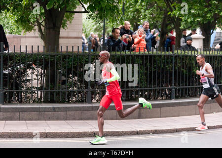 Sir Mo Farah (GBR), die durch die North Colonnade, Canary Wharf, dicht gefolgt von Leul Gebresilasie (ETH), während der 2019 London Marathon gefolgt. Bei den Herren Elite Rennen, Mo ging zum 5. zu beenden, in einer Zeit von 02:05:39. Leul wurde 8. in einer Zeit von 02:07:15 Stockfoto