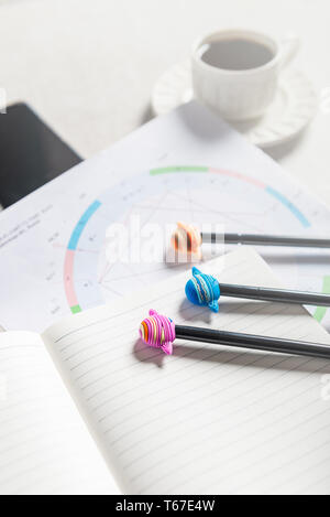 Offenen Notebooks für das Schreiben von Ideen und astrologische Geburt Geburtshoroskop Festlegung auf grauem Hintergrund. Kaffee und Planeten Stifte in der Nähe. Ansicht von oben. Idee der Astrol Stockfoto