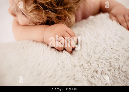 Baby's Hand auf einen flauschigen weißen Decke Stockfoto