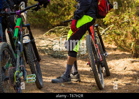 Eine Gruppe von drei Freunden chatten, während der Rest unter während einer Radfahren Reiten im Wald Stockfoto