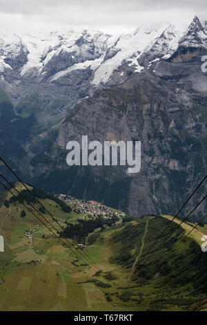 Blick hinunter nach Mürren vom Birg Seilbahnstation, mit das Jungfraumassiv und das Lauterbrunnental jenseits, Berner Oberland, Schweiz Stockfoto