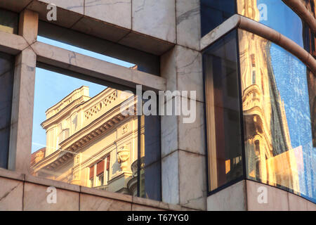 Klassische Architektur Gebäude spiegelt sich in einem modernen Gebäude Glaswand verzerrt. Moderne vs. Belgrad, Serbien. Abstraktes Bild Bilder Stockfoto
