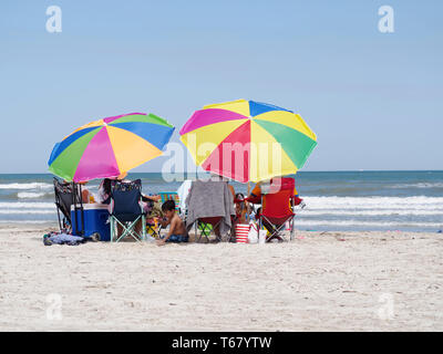 Bunte Sonnenschirme Schatten beachgoers auf einem Golf von Mexiko Strand während der 2019 Texas Sandfest in Port Aransas, Texas USA. Stockfoto