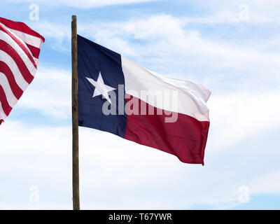 Das Texas State Flag oder 'Lone Star Flag", fliegt gegen den blauen Himmel mit weißen Wolken am2019 Texas Sandfest in Port Aransas, Texas USA. Stockfoto