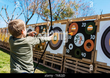 Valencia, Spanien - 29. April 2019: Kinder spielen mit einem Bogen und Pfeile werfen Sie gegen einen Bullseye. Stockfoto