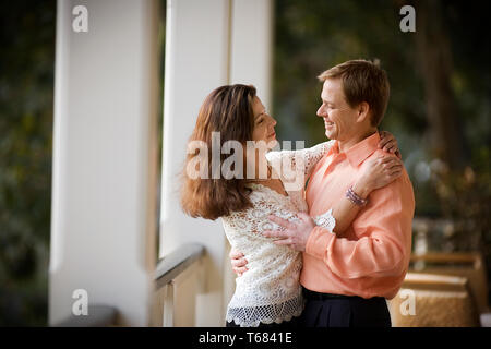 Lächelnd Mitte - erwachsene Paare tanzen zusammen auf einem Balkon. Stockfoto