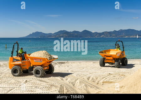 CANNES, Frankreich - April 2019: Muldenkipper transportieren Sand über den Strand in Cannes für den Frühling und Sommer Saison bereit Stockfoto