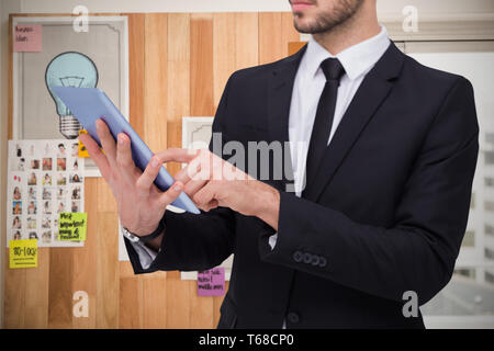 Zusammengesetztes Bild des Innenfeldes eines Geschäftsmannes mit digitalen TabletPC Stockfoto