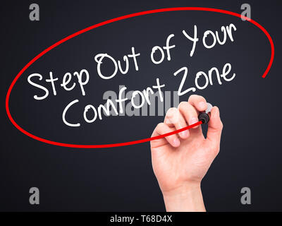 Mann Hand schreiben Schritt aus Ihrer Komfortzone mit schwarzem Marker auf visuelle Bildschirm. Stockfoto