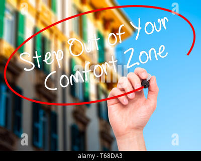 Mann Hand schreiben Schritt aus Ihrer Komfortzone mit schwarzem Marker auf visuelle Bildschirm. Stockfoto
