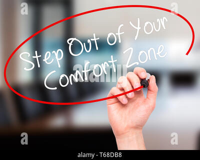 Mann Hand schreiben Schritt aus Ihrer Komfortzone mit schwarzem Marker auf visuelle Bildschirm. Stockfoto