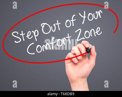Mann Hand schreiben Schritt aus Ihrer Komfortzone mit schwarzem Marker auf visuelle Bildschirm. Stockfoto