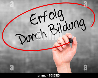 Mann Hand schreiben Erfolg durch Bildung (Erfolg durch die Ausbildung in Deutsch) mit schwarzem Marker auf visuelle Bildschirm. Stockfoto