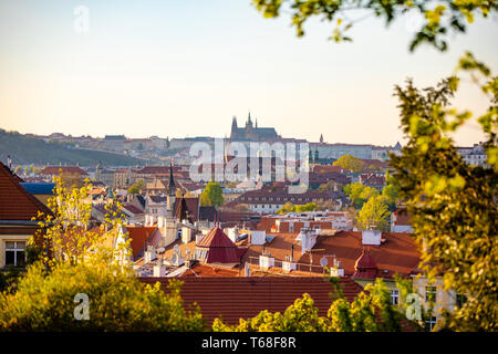 Blick auf die Prager Burg über den roten Dach von Vyšehrad Bereich bei Sonnenuntergang leuchten, Prag, Tschechische Republik Stockfoto