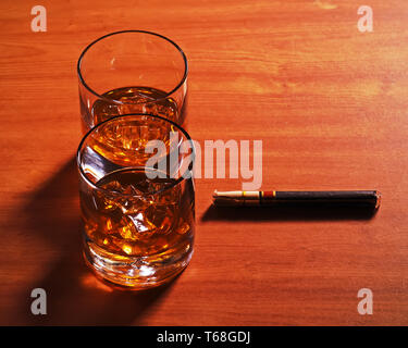 Highball Whiskey Glas mit Eis und Zigarre auf Holz- Hintergrund. Stockfoto