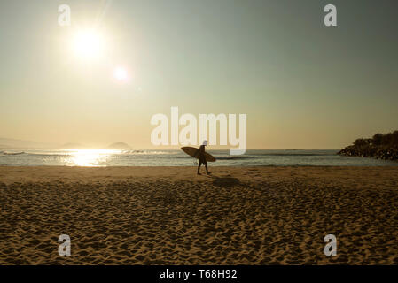 Surfer zu Fuß auf den Strand von Chacahua, Oaxaca, Mexiko. Apr 2019 Stockfoto