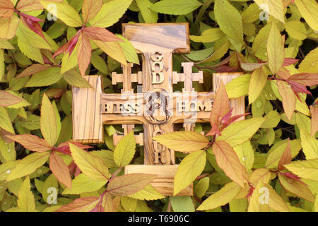 Croix de Jérusalem en bois d'Olivier représentant Jésus-Christ sur de la végétation Jaune. Stockfoto