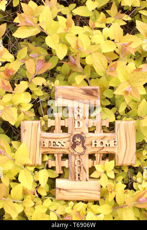 Croix de Jérusalem en bois d'Olivier représentant Jésus-Christ sur de la végétation Jaune. Stockfoto