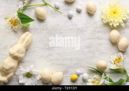 Schöne Ostern Komposition mit Schokolade Hase, Eier und Blumen auf Holz- Hintergrund, Ansicht von oben Stockfoto