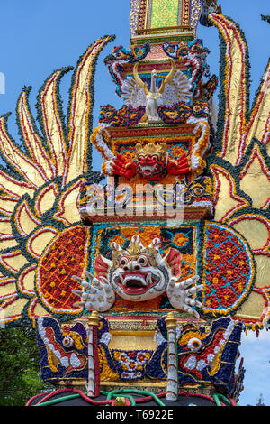 Bade Einäscherung Turm mit traditionellen balinesischen Skulpturen der Dämonen und Blumen in der Central Street in Ubud, Insel Bali, Indonesien. Für eine vorbereitet Stockfoto